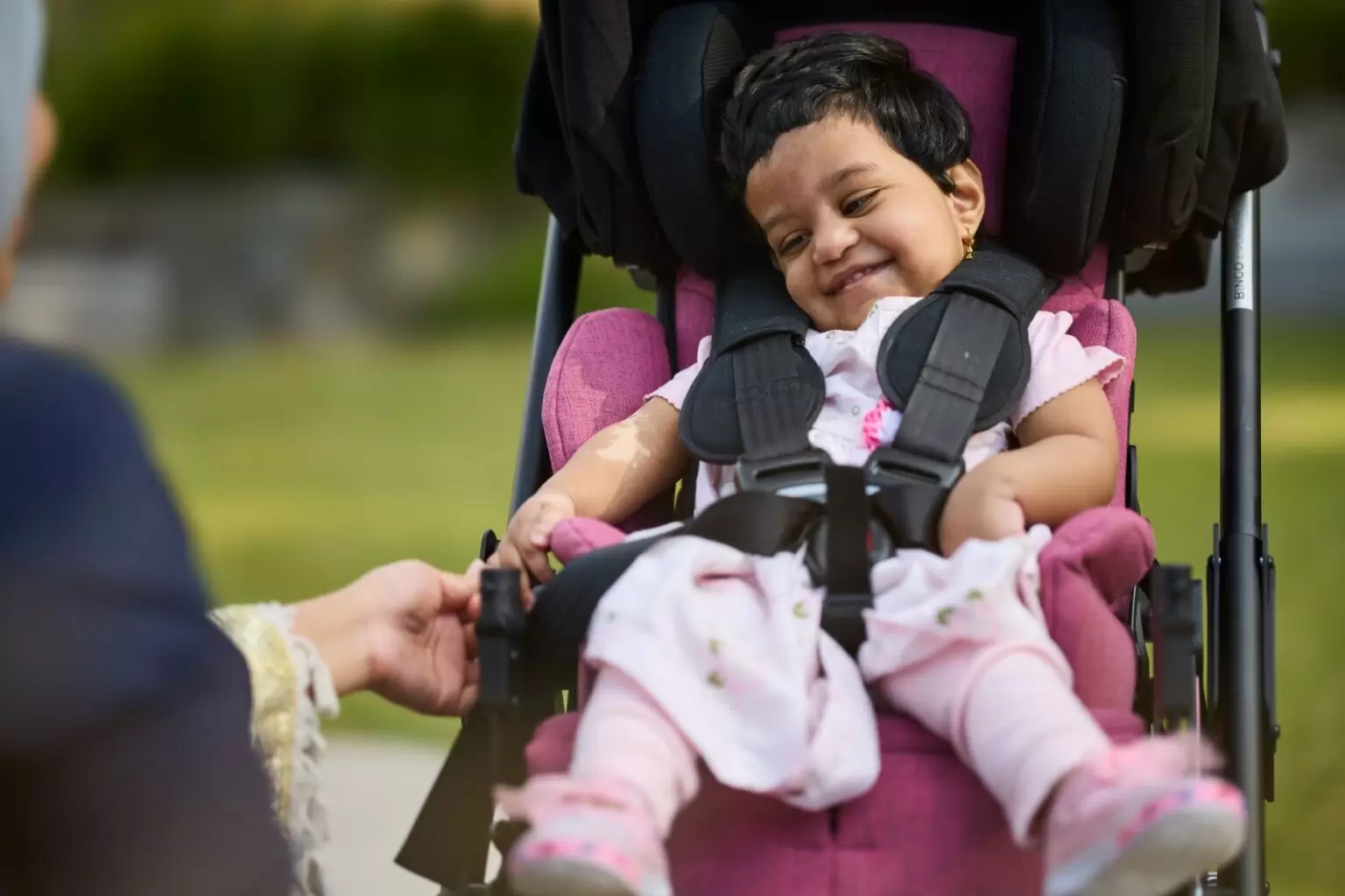 Grant recipient Huda happy in specialised pram